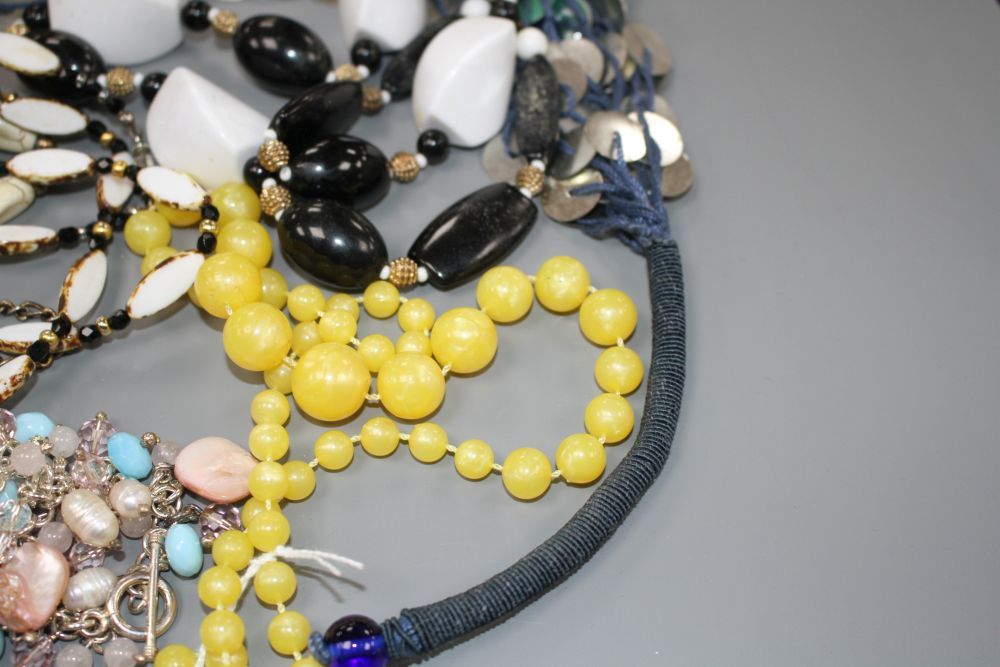 Six assorted costume necklaces including simulated amber and a costume bracelet,